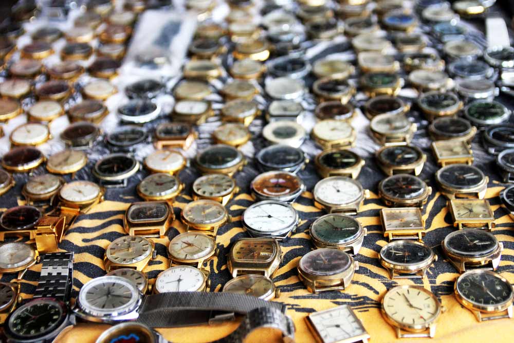 Various vintage watch faces laid out on a table.
