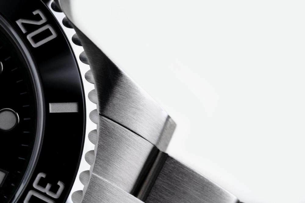 A close-up of a watch face, brought by a collector in person to a store as they debate where to sell their Rolex and whether to go local vs. Online.