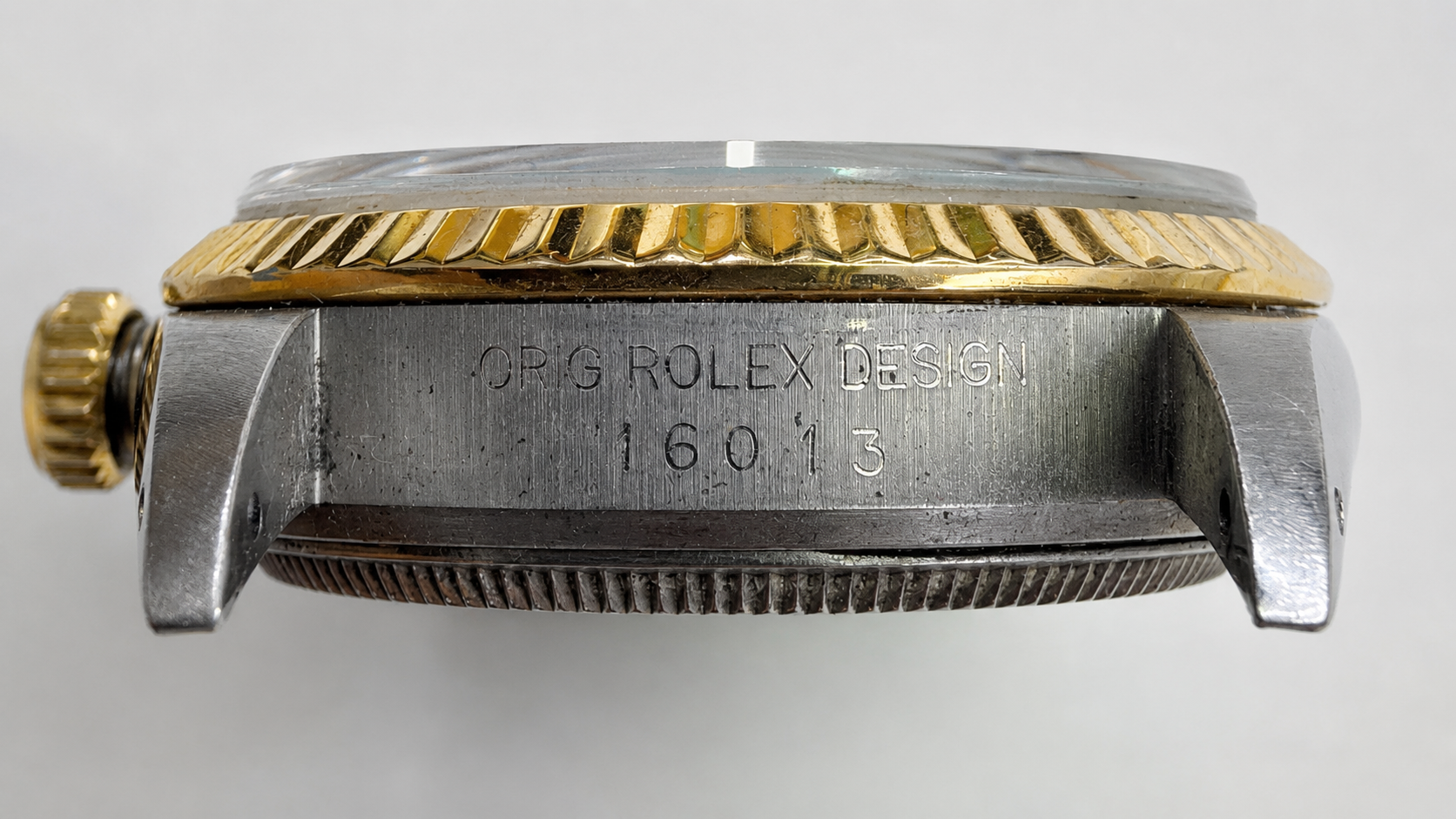 Rolex model number location: engraved between the lugs at 12 o'clock, opposite the serial number