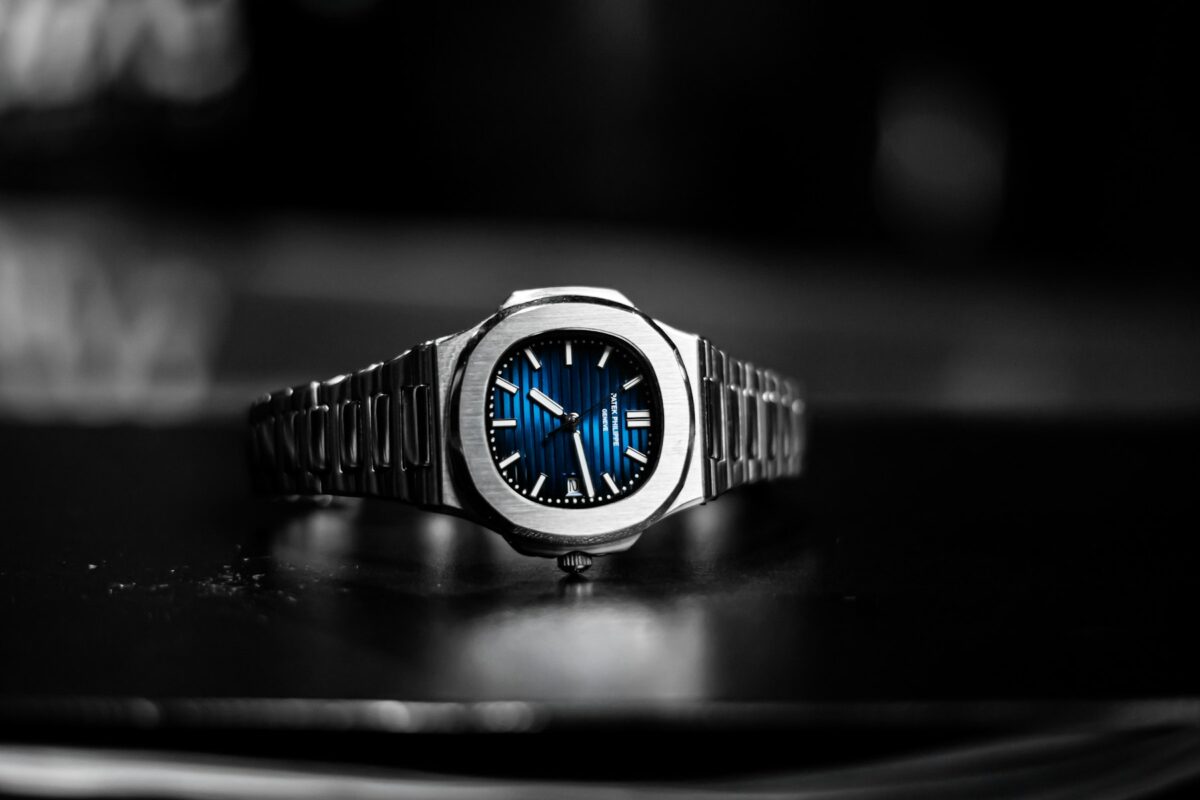 Patek Philippe Nautilus with a blue dial and stainless steel integrated bracelet on a dark tabletop