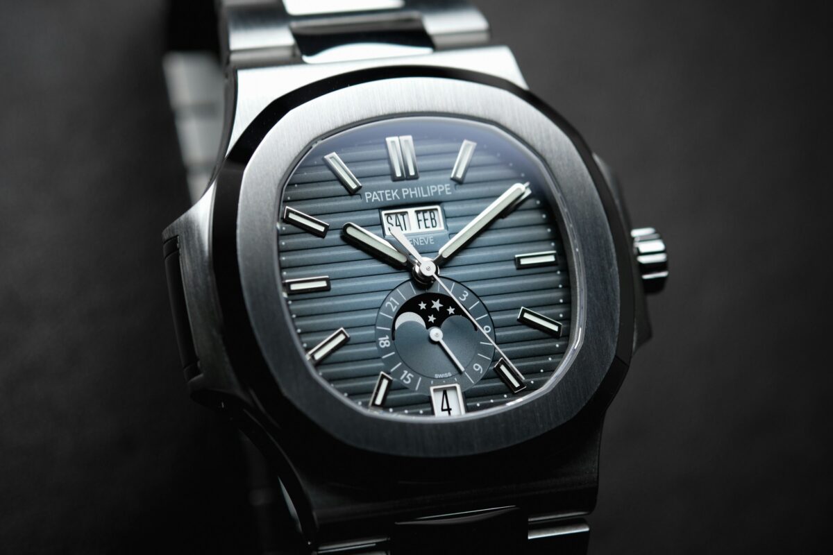 Patek Philippe Nautilus with a blue-gray dial, calendar windows, moon-phase display and stainless steel bracelet.